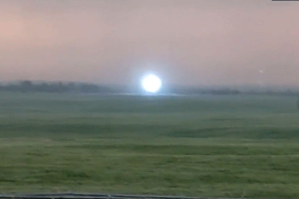 Светящаяся шаровая молния, парящая над зелёным полем под пасмурным небом (Glowing Ball Lightning Hovering Over a Green Field Under a Cloudy Sky)